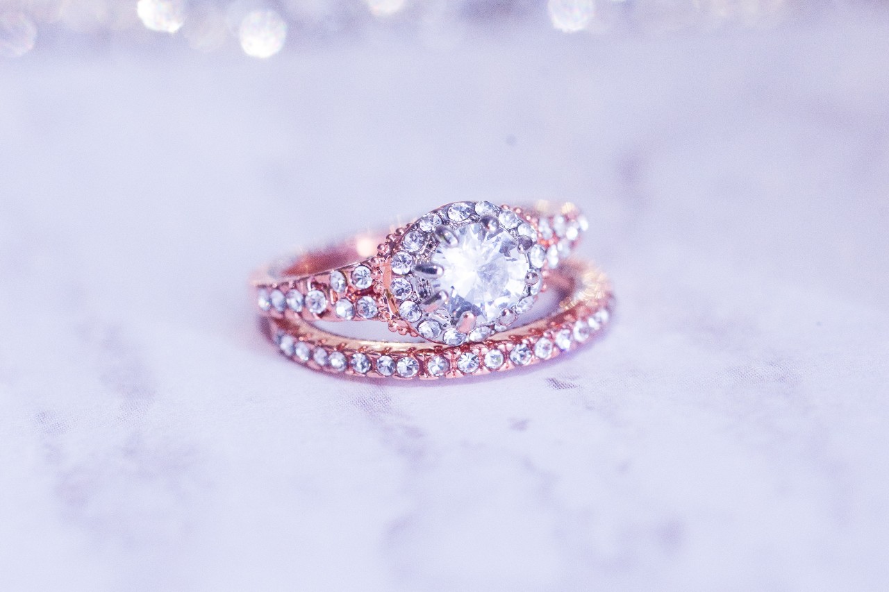 Rose gold diamond engagement ring with a round center stone and side-set diamond pave