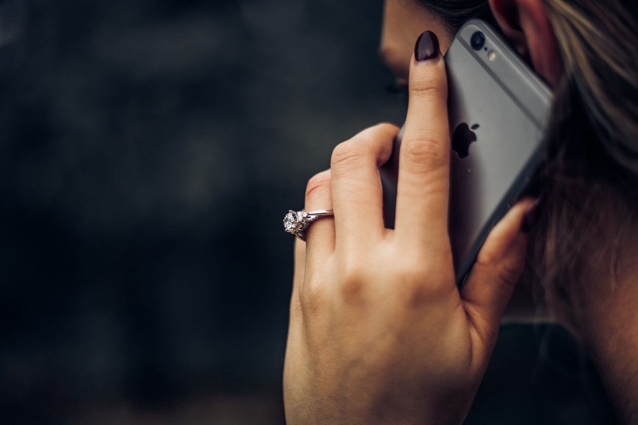 Chic lady on the phone. Her eye-catching engagement ring shine brightly on her finger