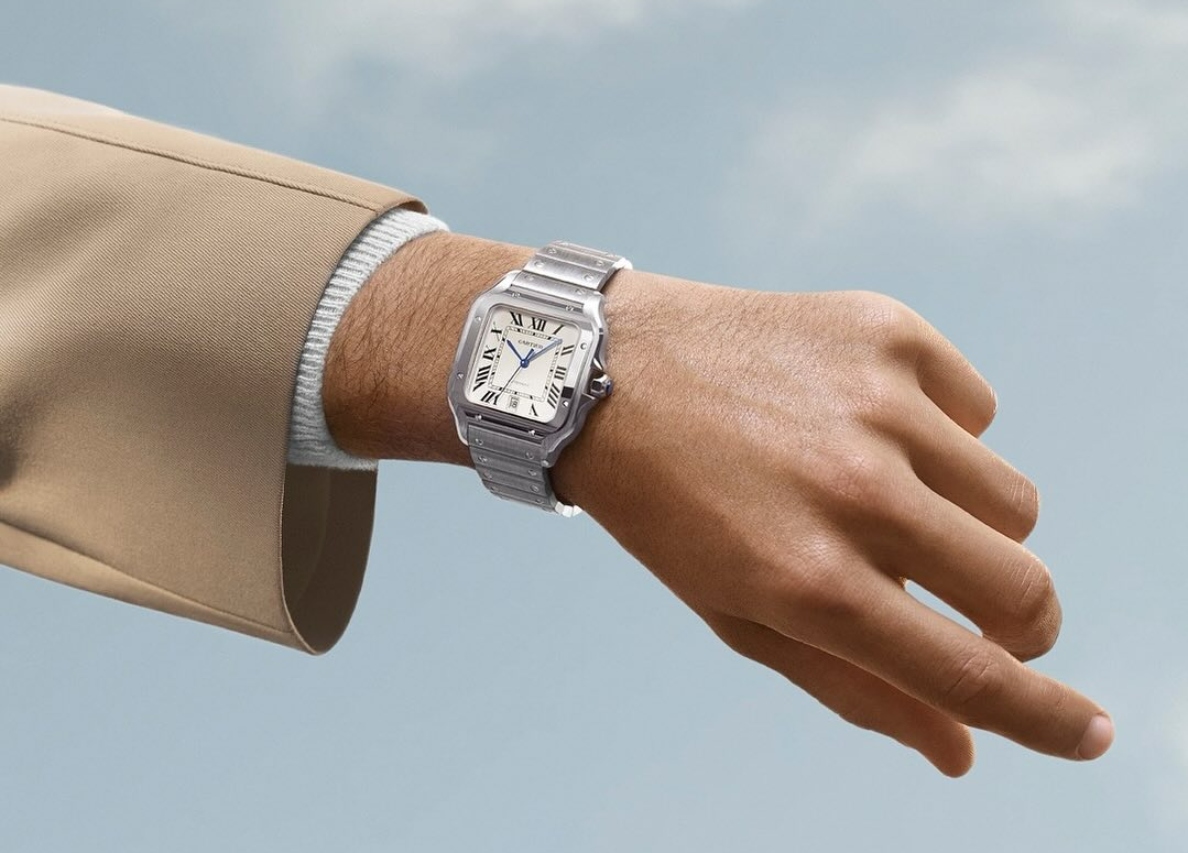 A close-up of a man’s wrist as he checks his luxury watch.