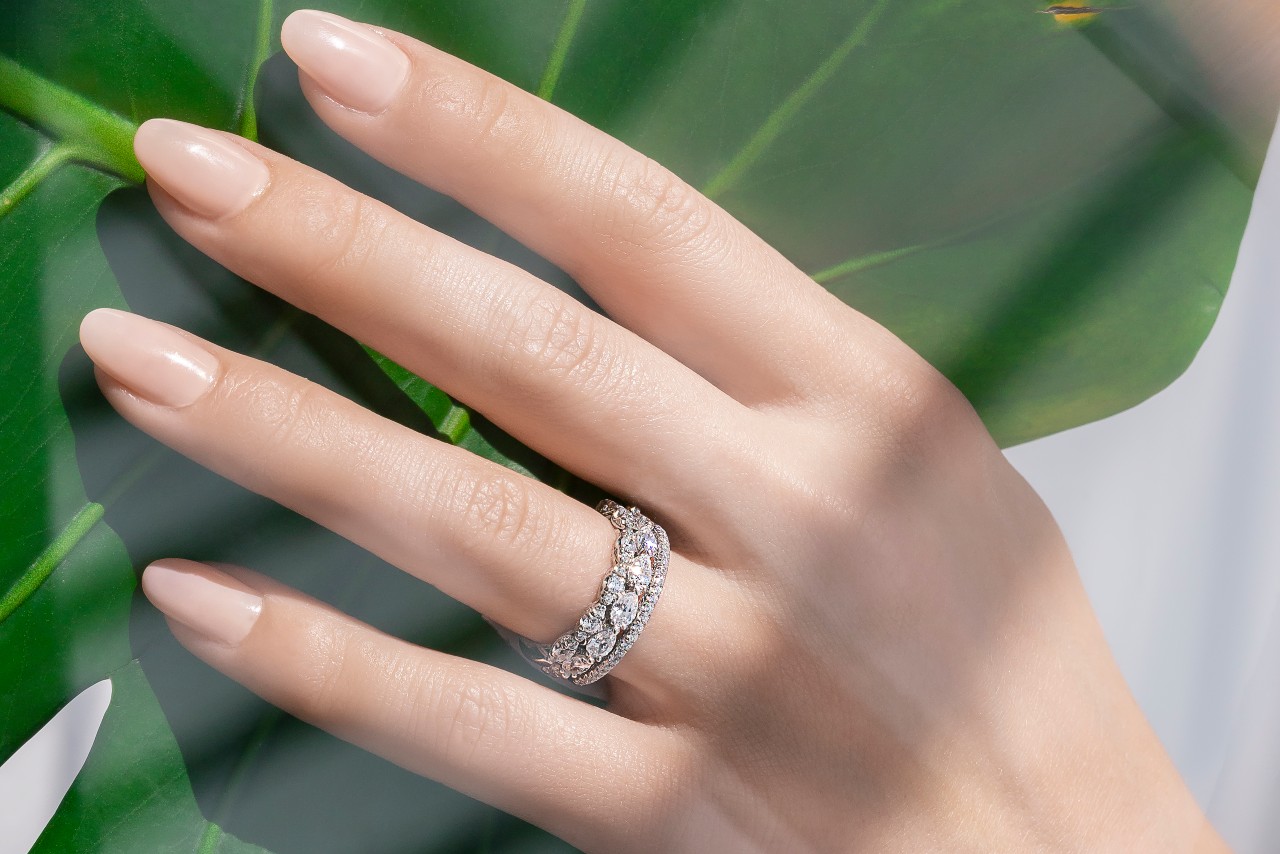 a lady’s hand wearing wedding bands by TACORI