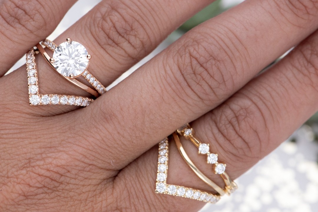 a close up of a hand wearing diamond rings by Hearts On Fire