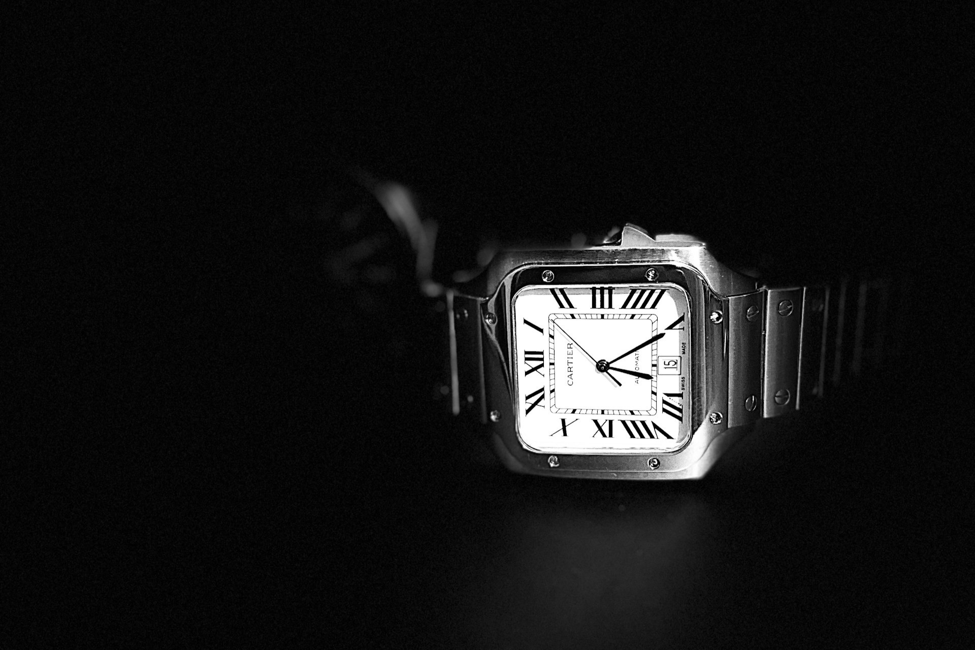 a Santos de Cartier watch on a black background